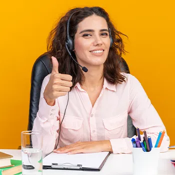 woman giving a thumbs while on a work desk