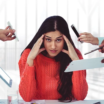 Stressed woman in red ignoring her coworkers from giving her tasks