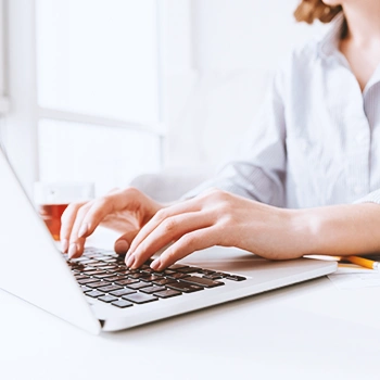 A person using a white laptop