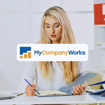 MyCompanyWorks logo with a business woman doing paperwork in the background