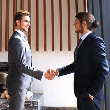 Two handsome business men shaking hands in an office