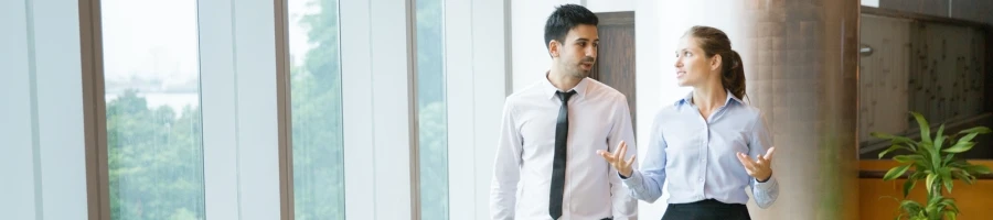 Two people discussing business while walking