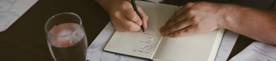 A man writing down in his notebook