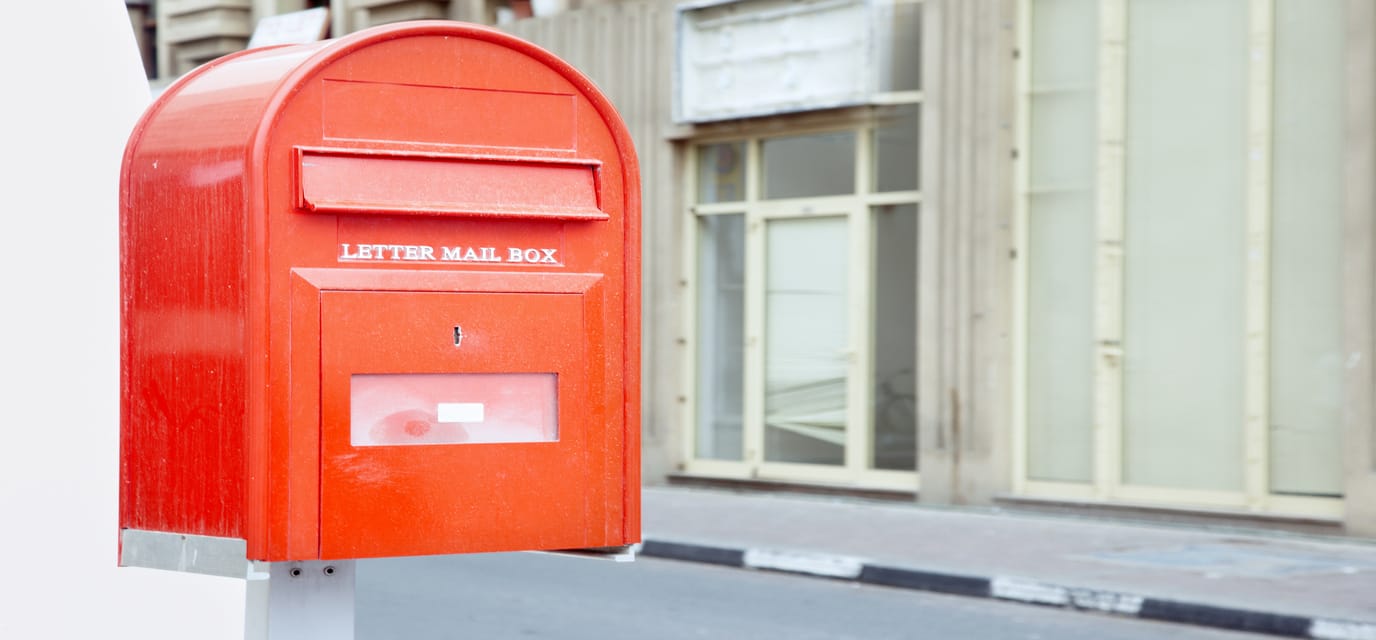 Red mail box outdoors with English text. Horizontal photo