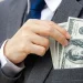 A business man putting money on his suit pocket for an LLC in Alabama